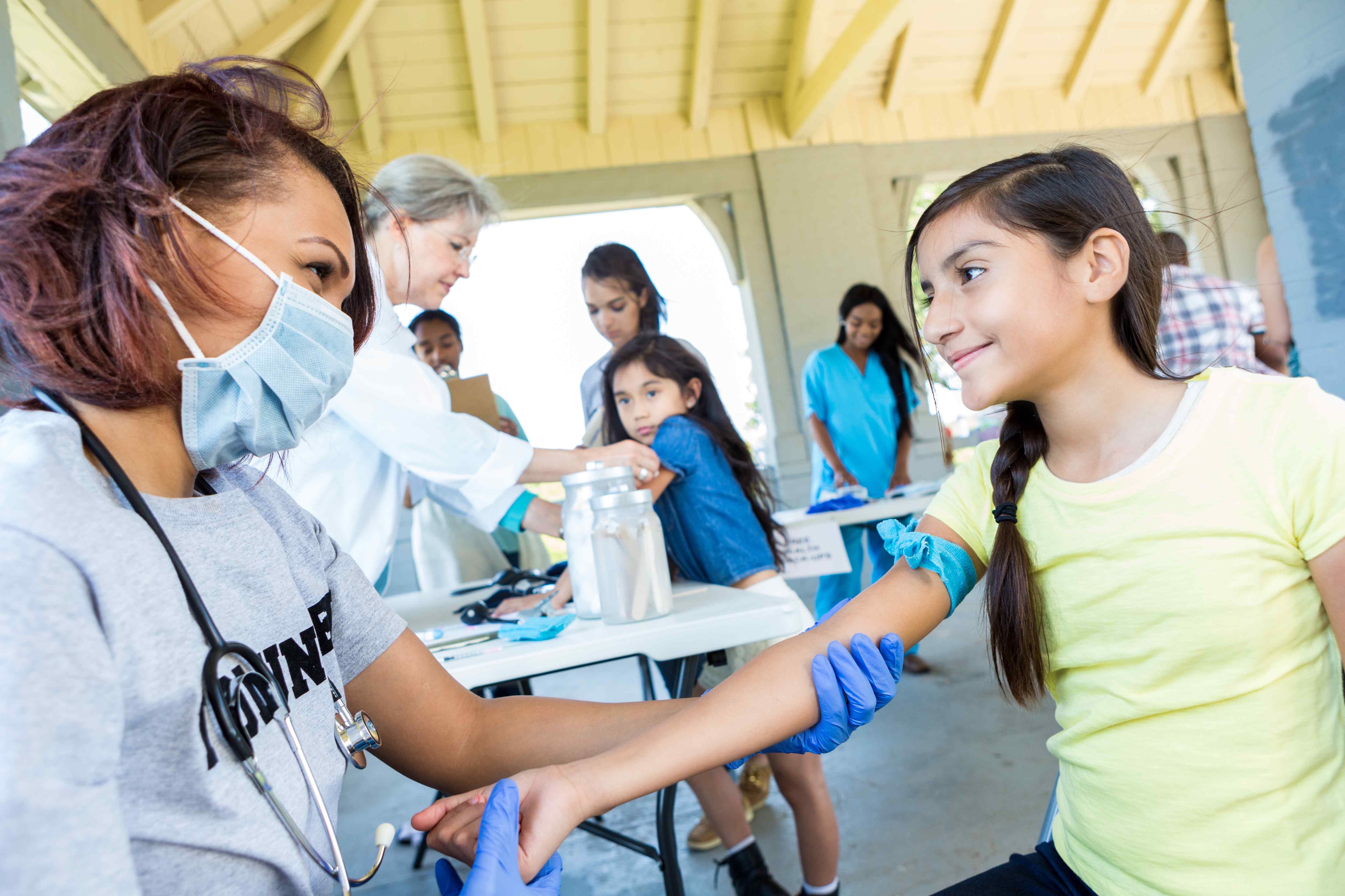 Image of Resolving Healthcare Challenges / Smiling girl receiving a medical examination