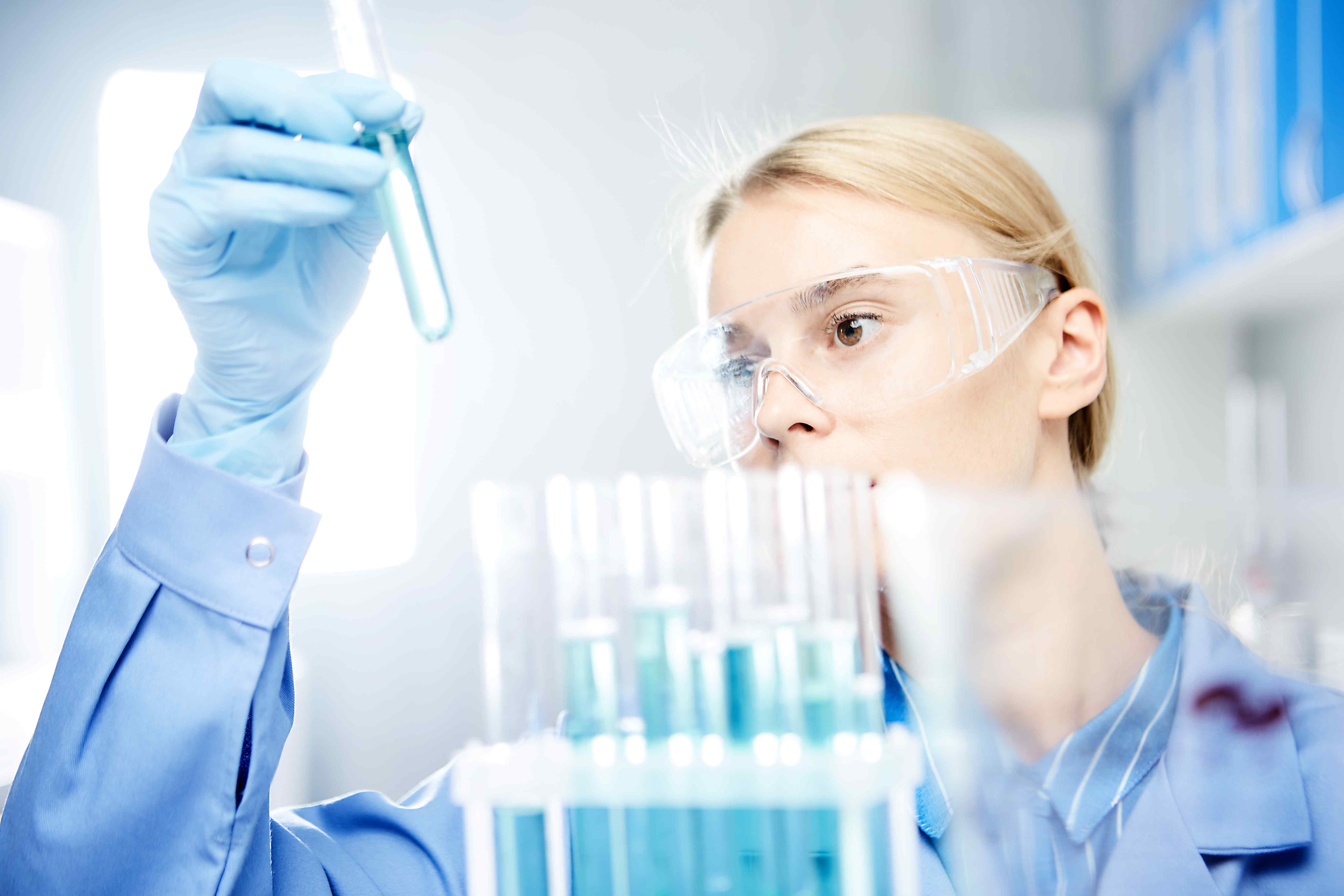 PharmaCeutical Solutions Business Image / Female researcher staring at test tubes